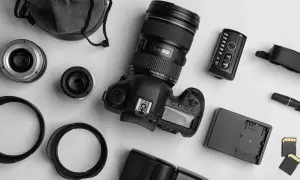 Zestaw do fotografii analogowej: aparat, obiektywy, lampa błyskowa, pilot, karty pamięci i futerał.