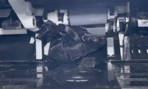 W drukarce zablokował się czarny, błyszczący materiał, przez co drukarka nie pobiera papieru.