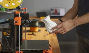 Ręce trzymają biały, falisty wazon wydrukowany na drukarce 3D. Plik dxf posłużył do stworzenia tego unikatowego przedmiotu.