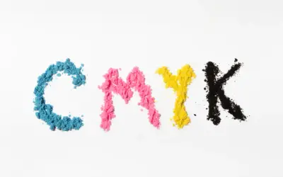 Litery CMYK uformowane z proszków: cyjan kolor, magenta, żółty i czarny.