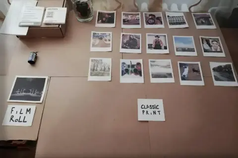 Zdjęcia z Rossmanna, różne rozmiary i motywy: portrety, krajobrazy, Nowy Jork, kontroler do gier. Obok rolka filmu.