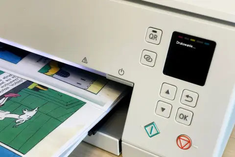 Drukarka drukuje komiks. Chcesz pobrać **adobe acrobat za darmo**? Zeskanuj kod QR lub użyj przycisku "OK".