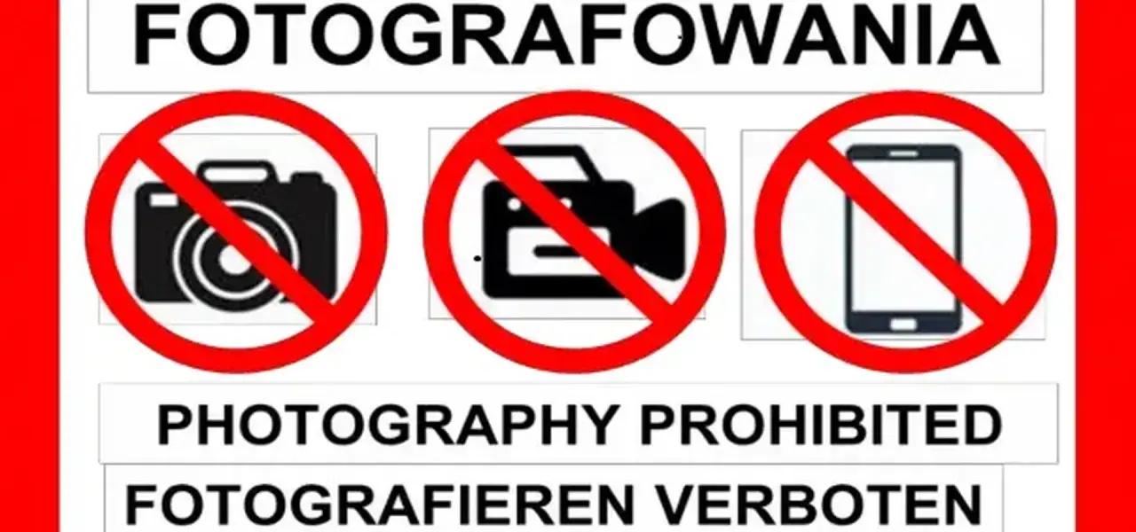 Tablica informuje o zakazie fotografowania. Widoczne są symbole aparatu, kamery i telefonu komórkowego przekreślone czerwoną linią.