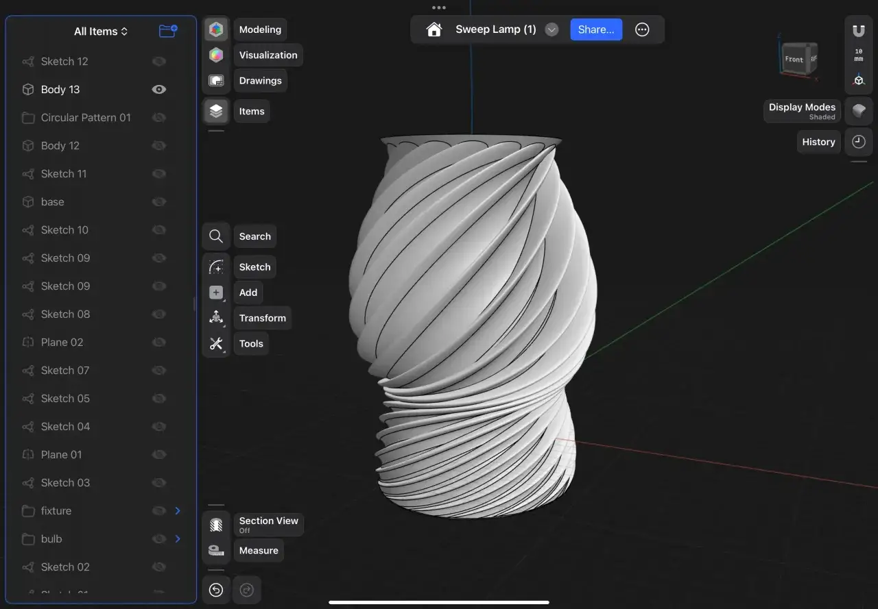 Projektant, inventor, tworzy w aplikacji 3D lampę o skręconym kształcie, widoczną na ekranie tabletu.