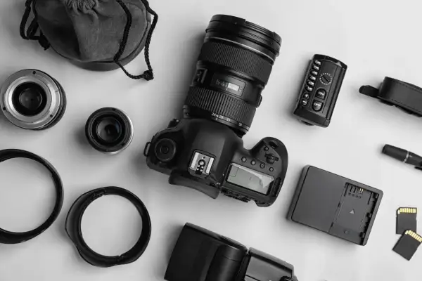 Zestaw do fotografii analogowej: aparat, obiektywy, lampa błyskowa, pilot, karty pamięci i futerał.