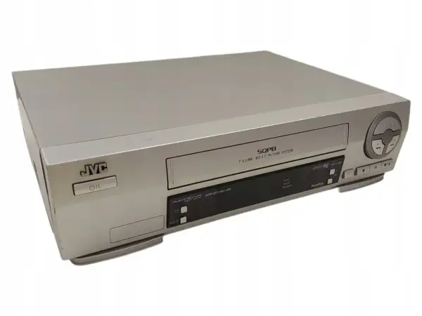 Srebrny vcr JVC z napisem SQPB. Urządzenie posiada przyciski sterujące i slot na kasetę.