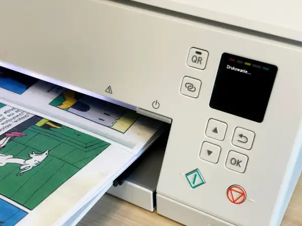 Drukarka drukuje komiks. Chcesz pobrać **adobe acrobat za darmo**? Zeskanuj kod QR lub użyj przycisku "OK".