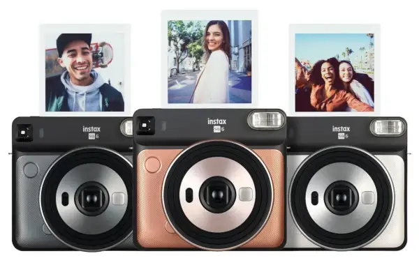 Aparat natychmiastowy Instax SQ6 w trzech kolorach: szarym, różowym i srebrnym. Nad aparatami widoczne są trzy zdjęcia zrobione tym modelem.